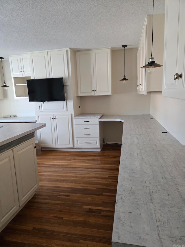 kitchen with decorative light fixtures, a textured ceiling, white cabinets, and dark wood-style flooring