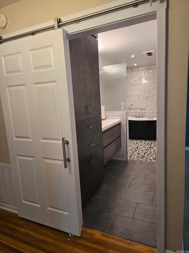 full bath featuring a shower, wood finished floors, vanity, and a washtub