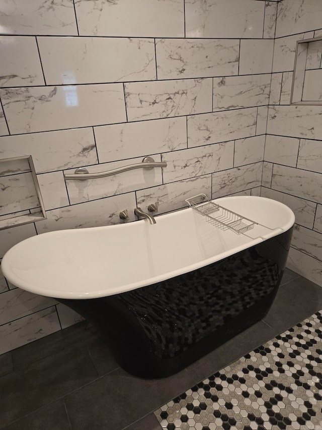 full bathroom with tile patterned floors, a freestanding bath, and tile walls