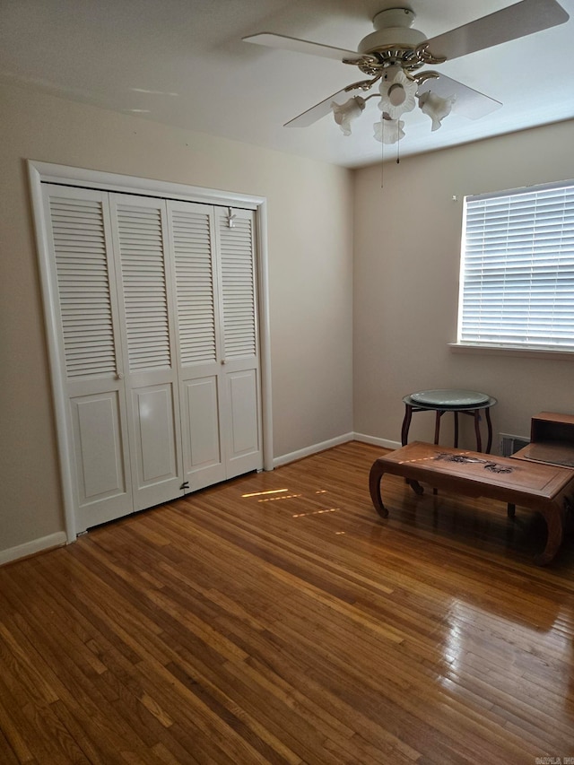 living area with wood finished floors, baseboards, and ceiling fan