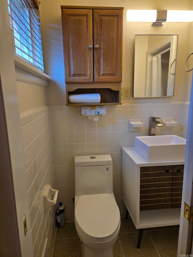 full bath featuring tile patterned flooring, wainscoting, toilet, and vanity