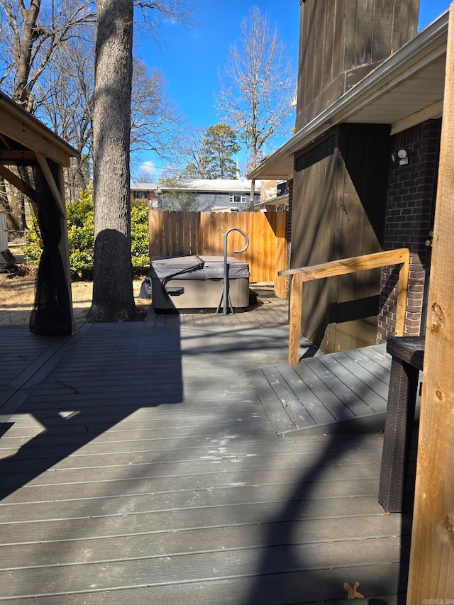 wooden deck featuring fence and a hot tub