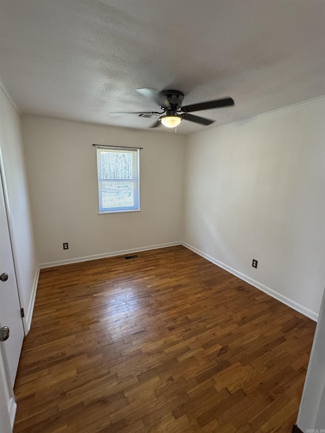 unfurnished room with visible vents, baseboards, dark wood-style floors, and a ceiling fan