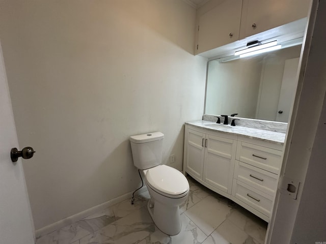 bathroom with vanity, toilet, baseboards, and marble finish floor