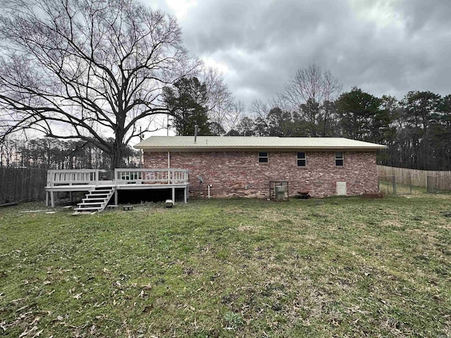 back of house with metal roof, a yard, fence, and a wooden deck