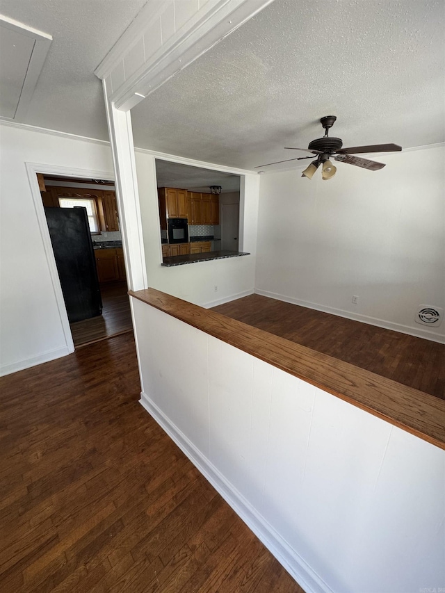 corridor featuring attic access, dark wood-style floors, visible vents, and a textured ceiling