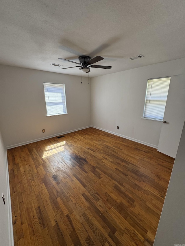 spare room featuring visible vents, a textured ceiling, ceiling fan, and hardwood / wood-style floors