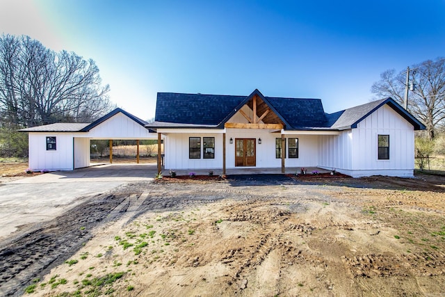 modern farmhouse style home with a carport, concrete driveway, french doors, and board and batten siding