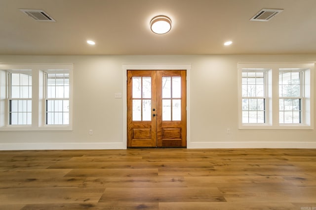 entryway with plenty of natural light, wood finished floors, and visible vents