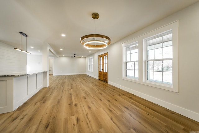 unfurnished dining area featuring light wood-style flooring, recessed lighting, and baseboards