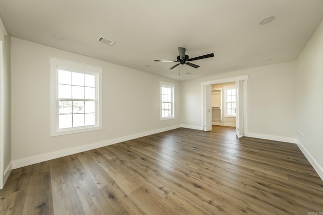 unfurnished bedroom with visible vents, ceiling fan, baseboards, and wood finished floors