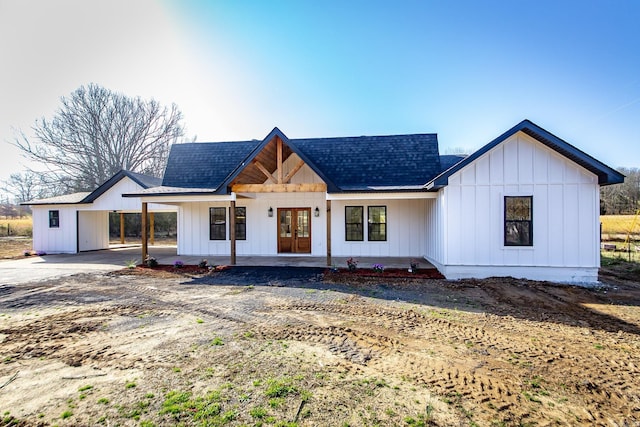 modern farmhouse featuring an attached carport, french doors, concrete driveway, and board and batten siding