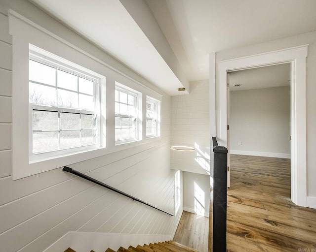 staircase featuring baseboards and wood finished floors