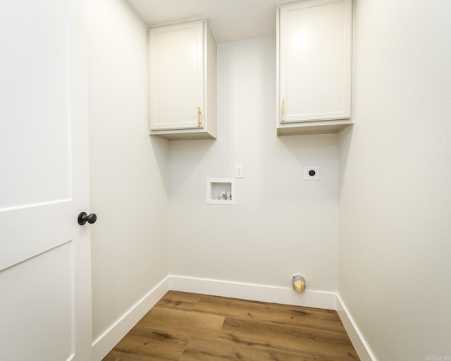 washroom with hookup for a washing machine, cabinet space, baseboards, and electric dryer hookup