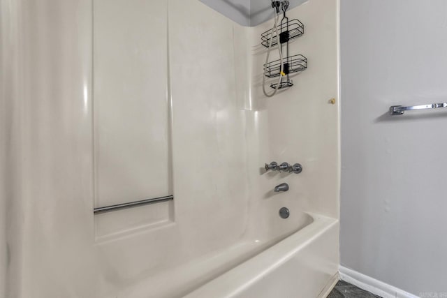 bathroom featuring shower / bathing tub combination and baseboards