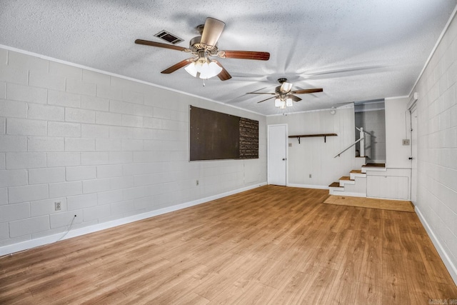 unfurnished living room with crown molding, ceiling fan, stairs, light wood-style flooring, and a textured ceiling