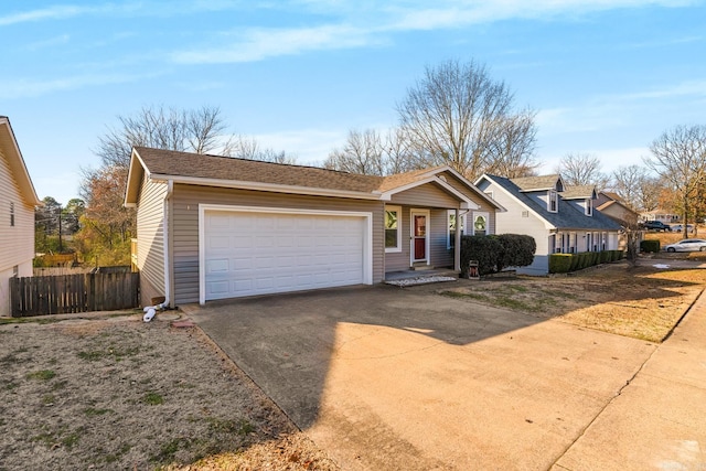 view of front facade featuring a residential view, an attached garage, concrete driveway, and fence