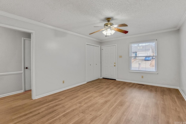 spare room featuring a textured ceiling, light wood-style flooring, a ceiling fan, and crown molding