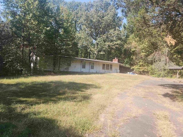 single story home with a front lawn and a chimney