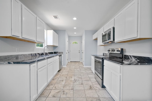 kitchen with a sink, white cabinetry, recessed lighting, appliances with stainless steel finishes, and baseboards