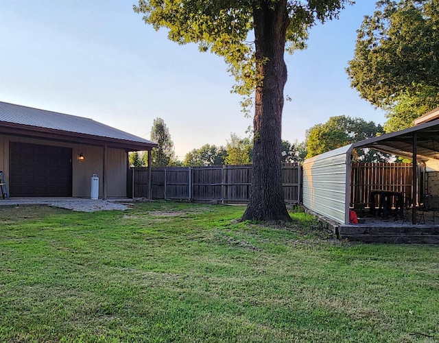 view of yard featuring a garage and a fenced backyard