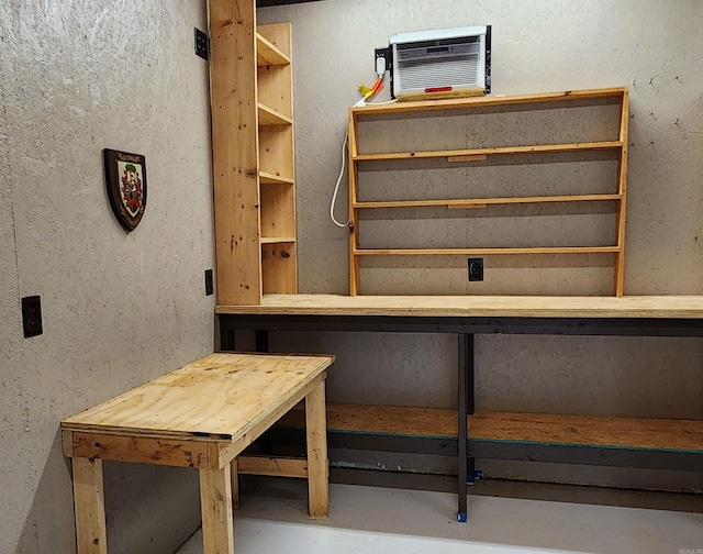 interior space featuring concrete flooring and a wall mounted air conditioner