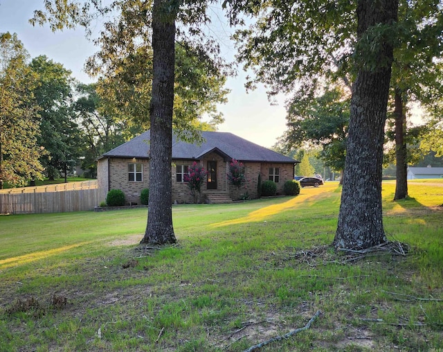 single story home featuring brick siding, a front yard, and fence