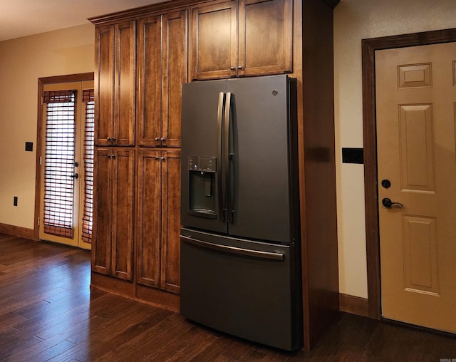 kitchen with dark wood-type flooring, a healthy amount of sunlight, and stainless steel refrigerator with ice dispenser