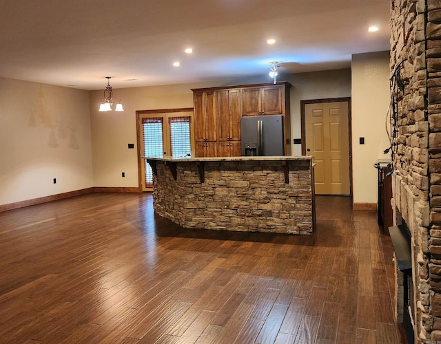 kitchen with dark wood-type flooring, recessed lighting, baseboards, and stainless steel refrigerator with ice dispenser