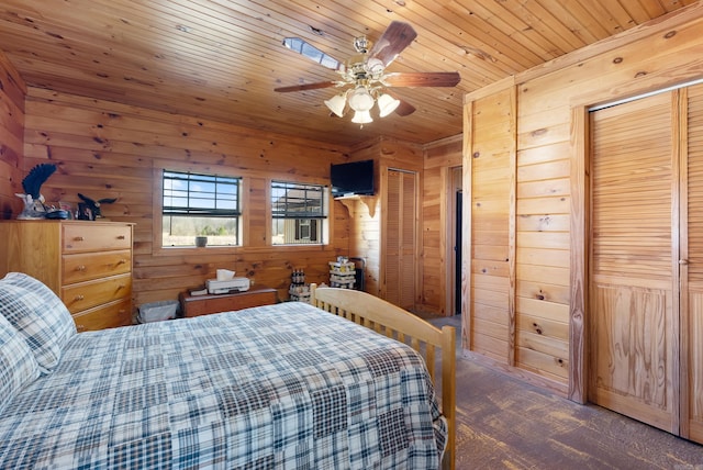 carpeted bedroom with wooden ceiling, wooden walls, and two closets