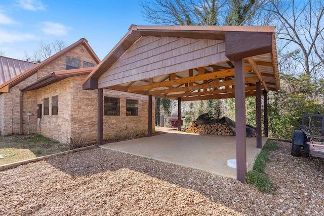 view of property exterior with a gazebo, stone siding, and a patio