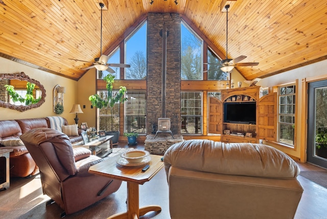 living area with a wealth of natural light, a ceiling fan, wood ceiling, and a wood stove