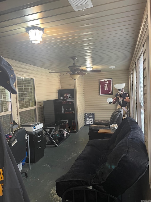 living area with visible vents, concrete flooring, and ceiling fan