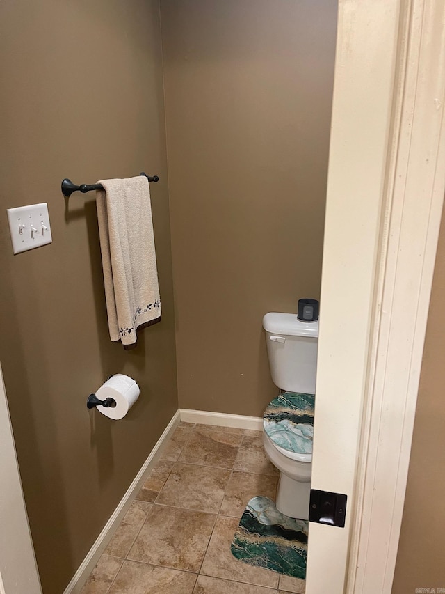 bathroom featuring tile patterned floors, toilet, and baseboards