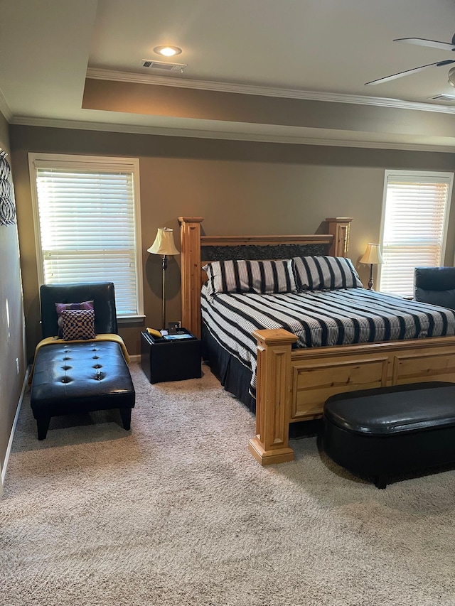 carpeted bedroom featuring visible vents, multiple windows, baseboards, and ornamental molding