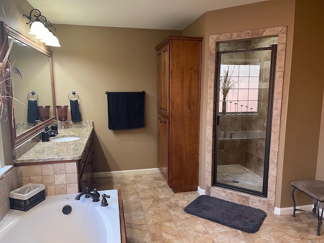 bathroom with baseboards, a shower stall, vanity, and a garden tub