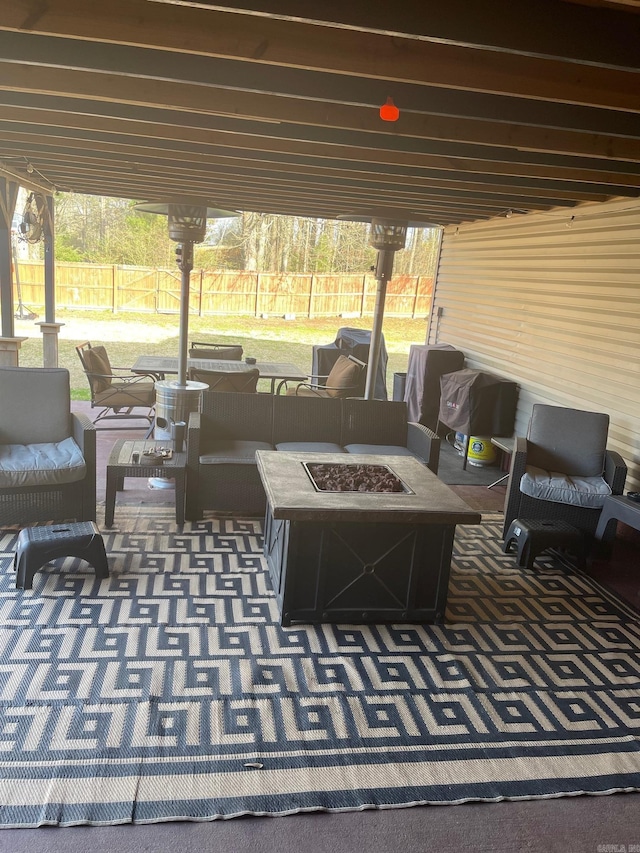 view of patio with an outdoor living space with a fire pit and fence