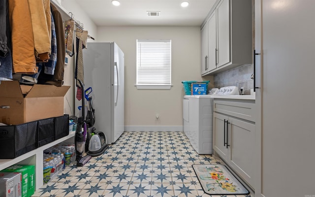 clothes washing area featuring visible vents, cabinet space, baseboards, light floors, and washing machine and clothes dryer