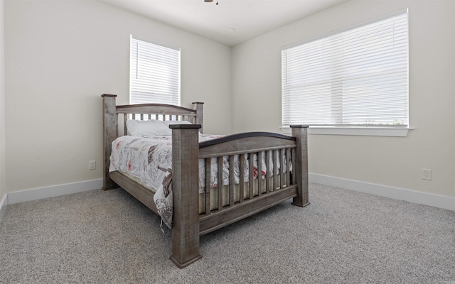 bedroom with multiple windows, carpet, and baseboards