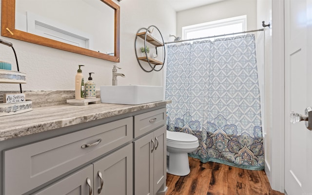 full bath featuring curtained shower, toilet, wood finished floors, and vanity