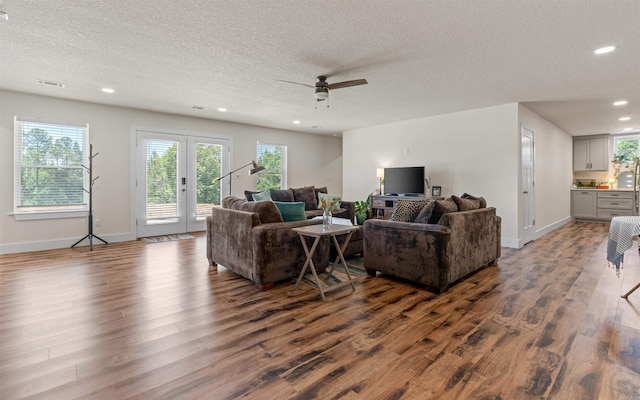 living room with baseboards, recessed lighting, a textured ceiling, a ceiling fan, and dark wood-style flooring