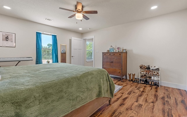 bedroom featuring visible vents, wood finished floors, recessed lighting, baseboards, and ceiling fan