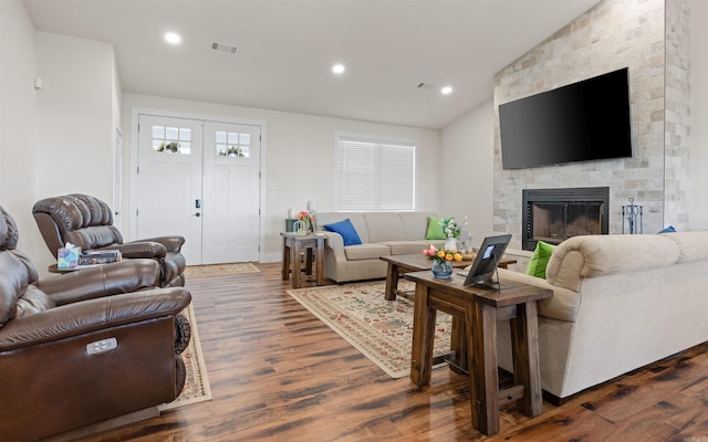 living room featuring visible vents, recessed lighting, a fireplace, vaulted ceiling, and dark wood-type flooring