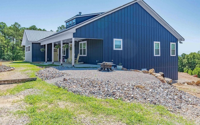 rear view of property featuring a patio, a ceiling fan, and board and batten siding