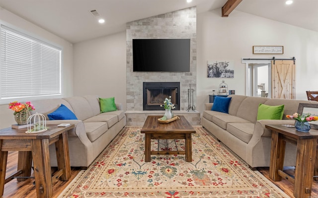 living room featuring lofted ceiling with beams, recessed lighting, visible vents, and a large fireplace