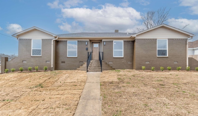 ranch-style home with crawl space, a shingled roof, brick siding, and a front yard