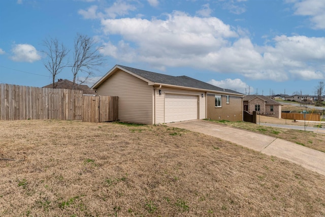 view of home's exterior featuring a garage, a yard, concrete driveway, and fence