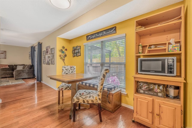 dining area featuring light wood-style floors and baseboards