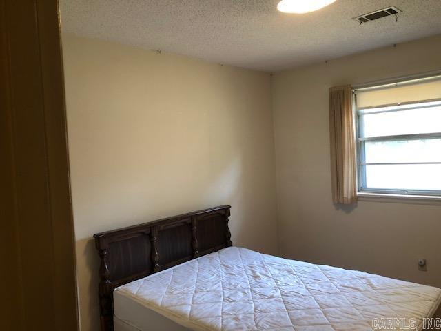 bedroom featuring visible vents and a textured ceiling