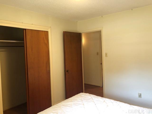 unfurnished bedroom with a closet and a textured ceiling